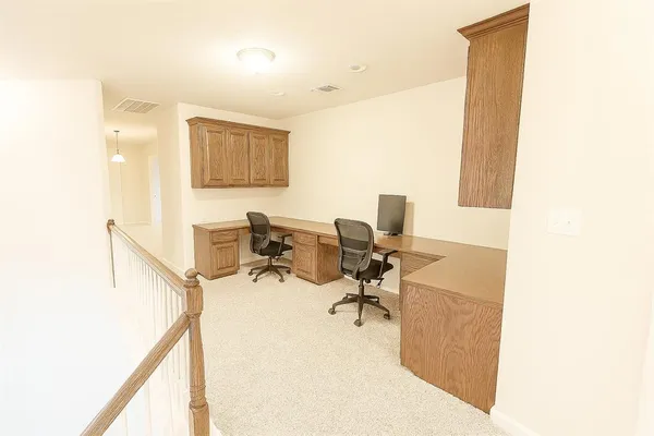 a view of a workspace with furniture and a window