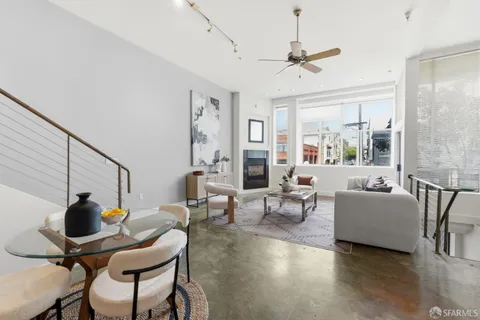 a living room with couches and a dining table with wooden floor