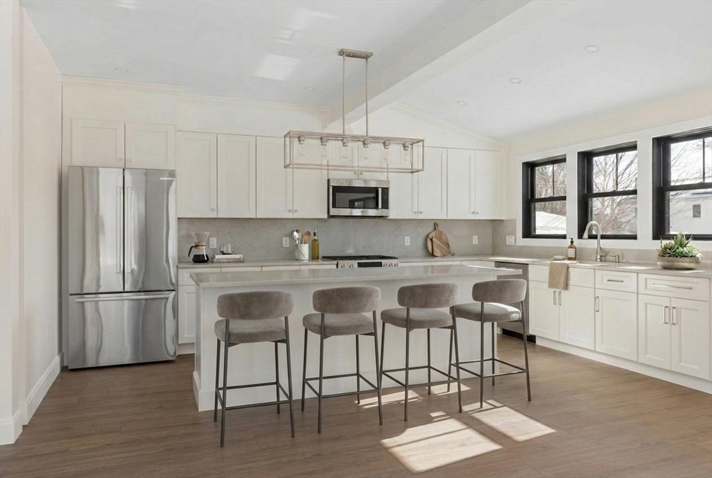 1864 River Street Boston, MA 02136 - Photo 12 of 38 a kitchen with stainless steel appliances granite countertop a stove a sink dishwasher a refrigerator and a dining table with wooden floor