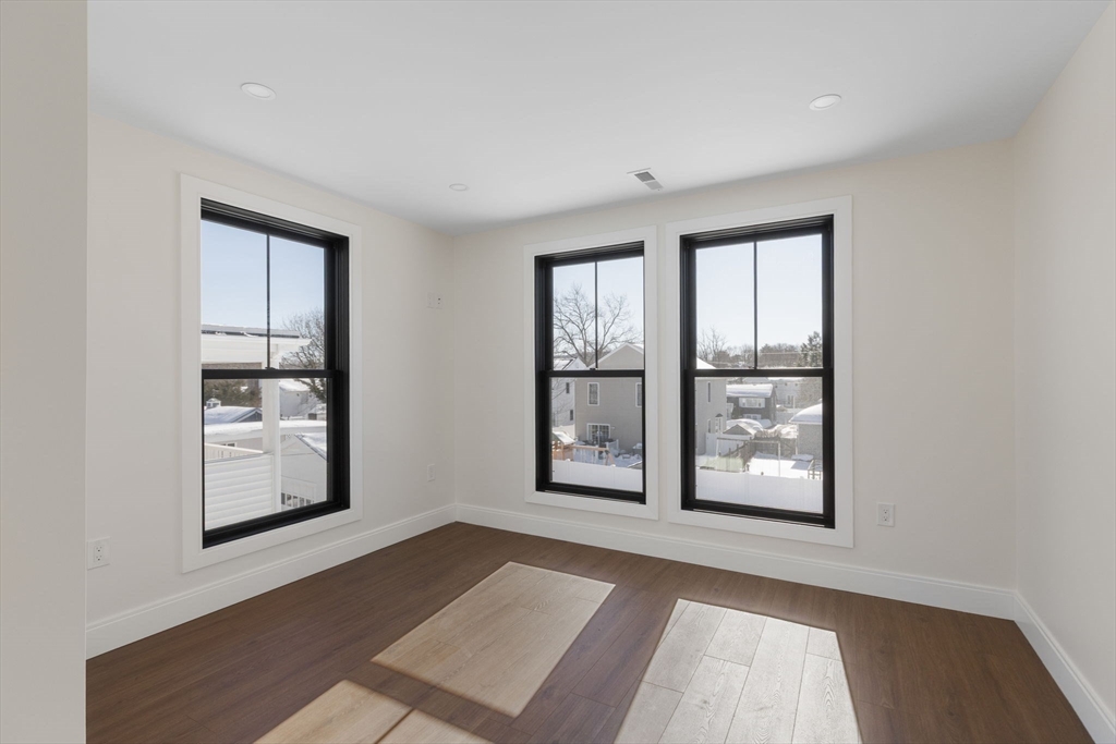 1864 River Street Boston, MA 02136 - Photo 21 of 38 an empty room with windows and ceiling fan
