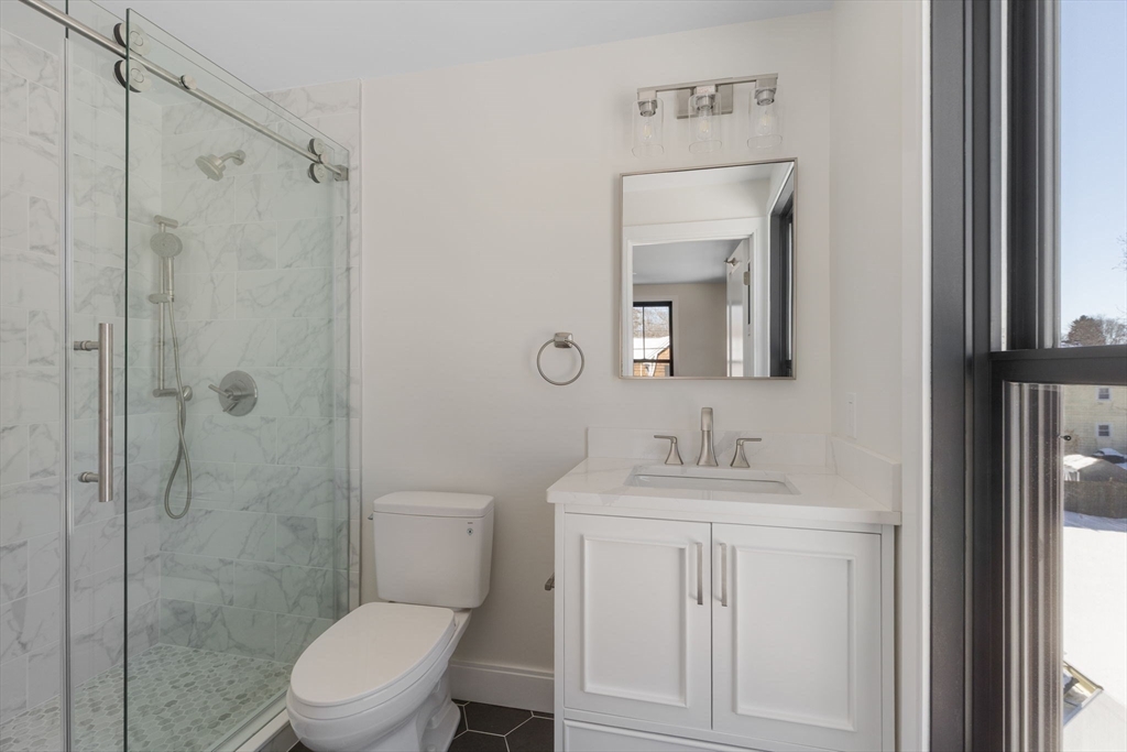1864 River Street Boston, MA 02136 - Photo 24 of 38 a bathroom with a toilet sink vanity and mirror