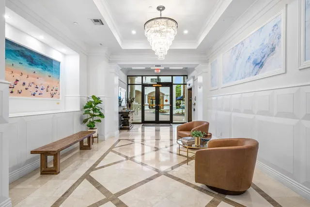 a living room with furniture chandelier and a large window