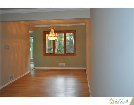 25 Hillwood Road East Brunswick, NJ 08816 - Photo 3 of 9 a view of an empty room with wooden floor and a window