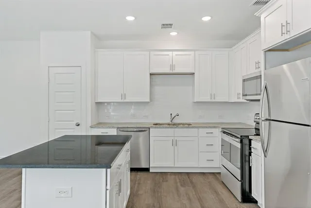 a kitchen with white cabinets sink and white appliances