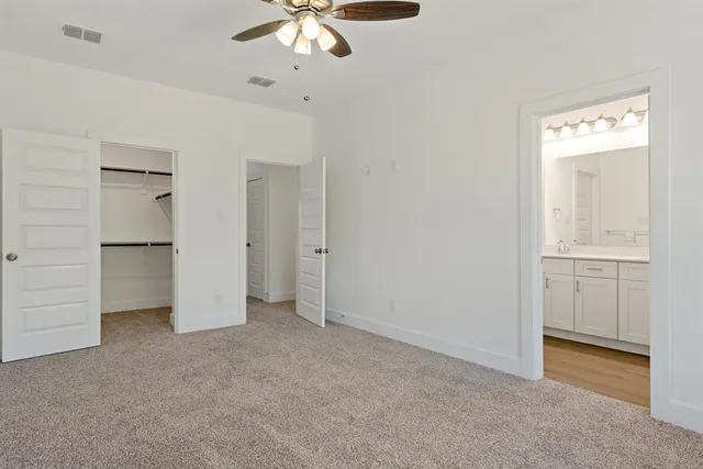 an empty room with closet and windows