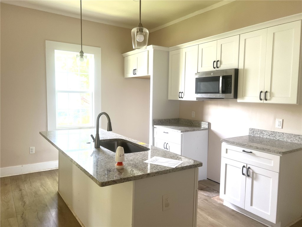 114 Shirley Street Anderson, SC 29621 - Photo 2 of 9 A well-appointed kitchen showcases granite counters, pristine cabinetry, and durable wood flooring.