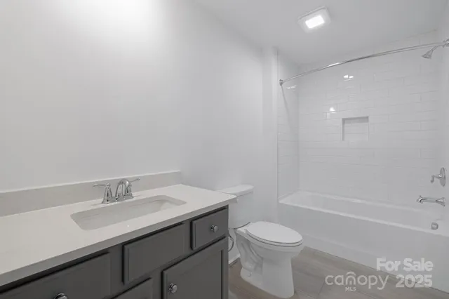 a spacious bedroom with a bed a couch and large window