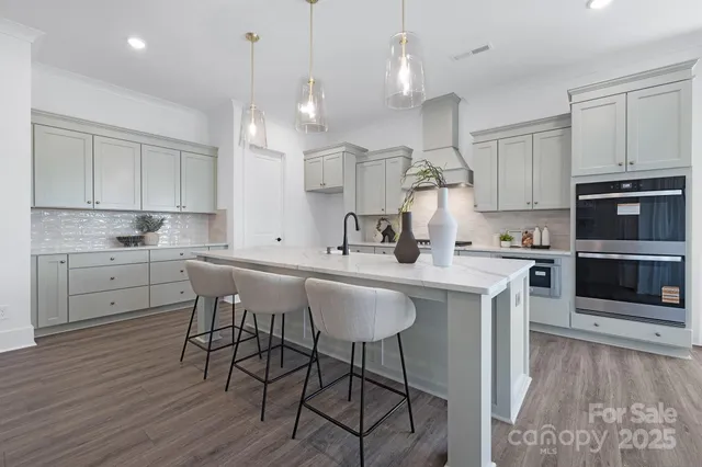 a kitchen with kitchen island granite countertop a sink a counter space stainless steel appliances and cabinets