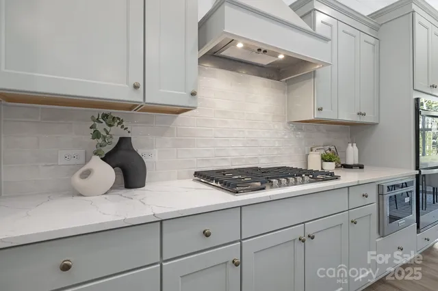 a kitchen with white cabinets and a stove