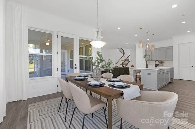 a dining room with furniture a chandelier and wooden floor
