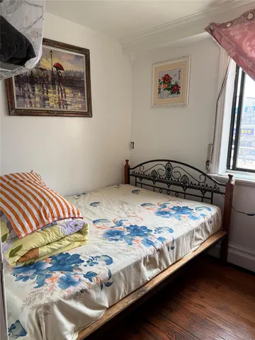 a bedroom with a bed and a painting on the wall