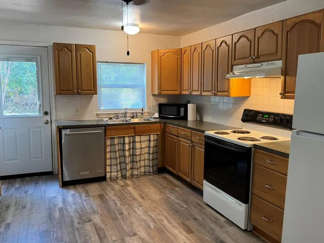 a kitchen with granite countertop wooden floors and stainless steel appliances