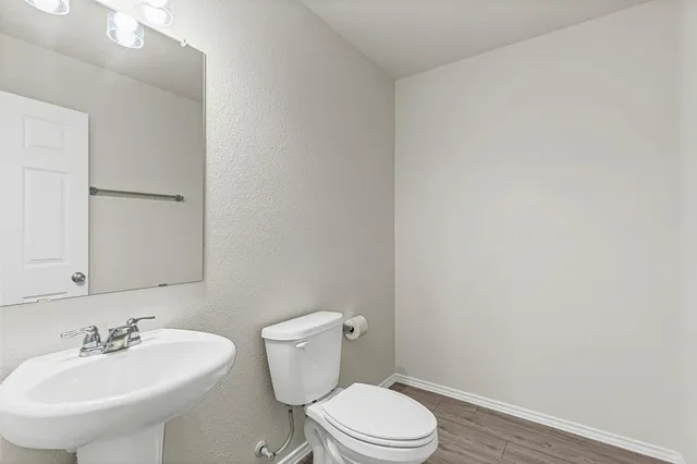 a bathroom with a toilet a sink and mirror