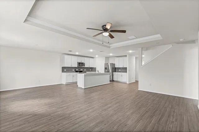 a view of kitchen with refrigerator microwave and wooden floor