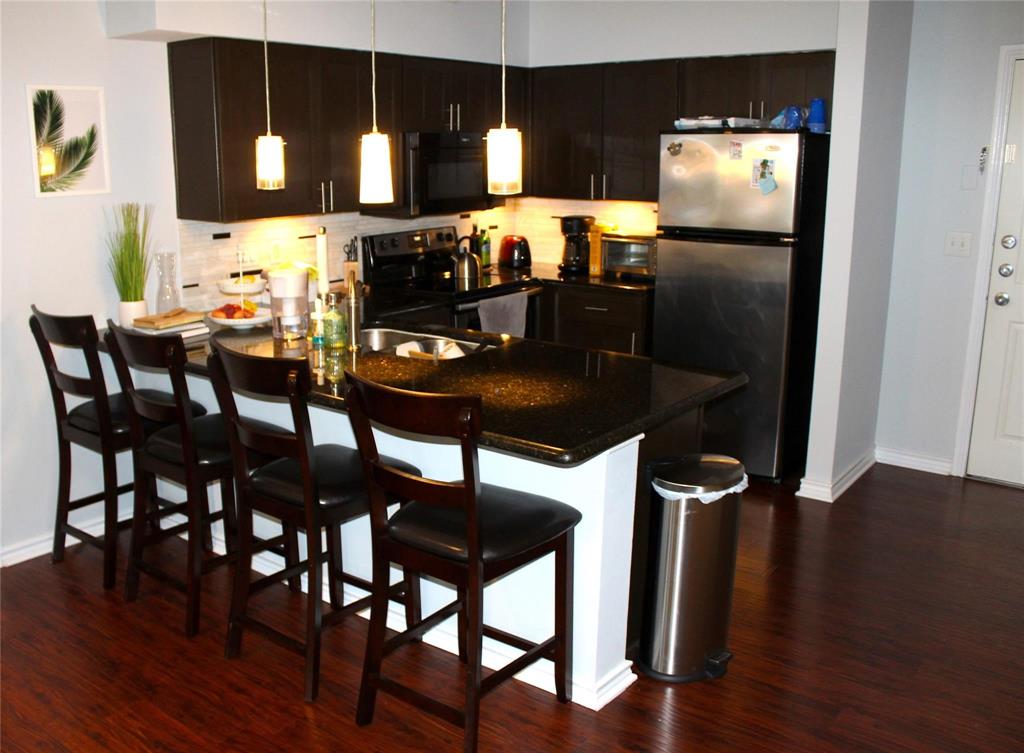 3102 Kings Road, Unit 1207 Dallas, TX 75219 - Photo 7 of 13 a kitchen with a table chairs and refrigerator