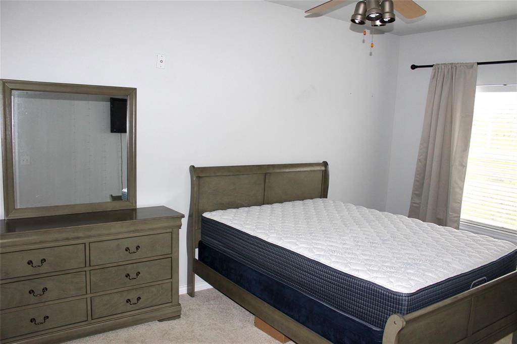 3102 Kings Road, Unit 1207 Dallas, TX 75219 - Photo 10 of 13 a bed sitting in a bedroom next to a window and a dresser