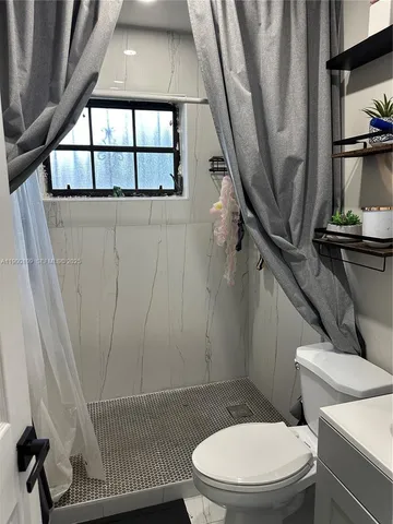 a white toilet sitting next to a window