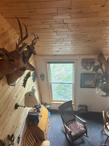 a kitchen with stainless steel appliances wooden floors and view of living room