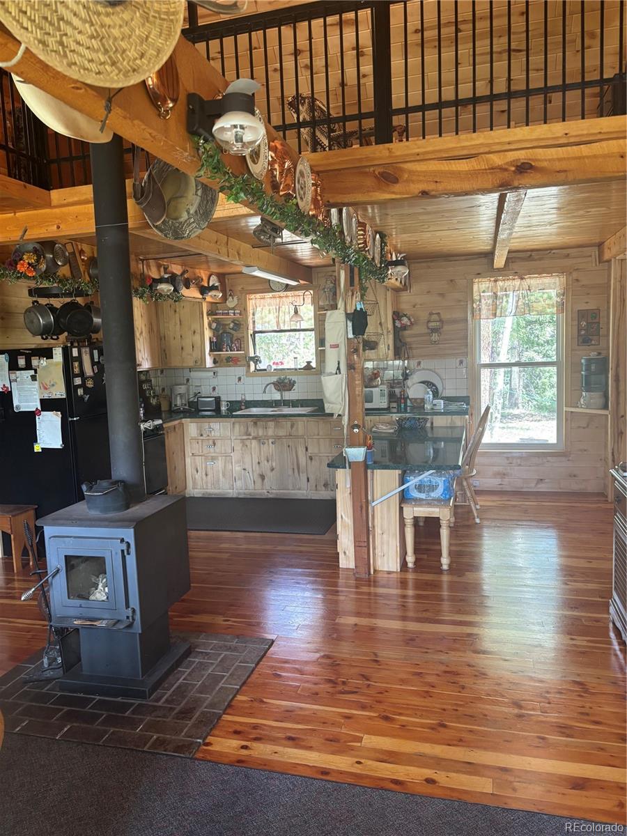1113 Spring Street Del Norte, CO 81132 - Photo 19 of 45 a kitchen with stainless steel appliances wooden floors and view of living room