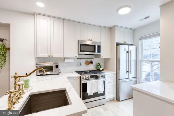 a kitchen with a sink a stove and a microwave