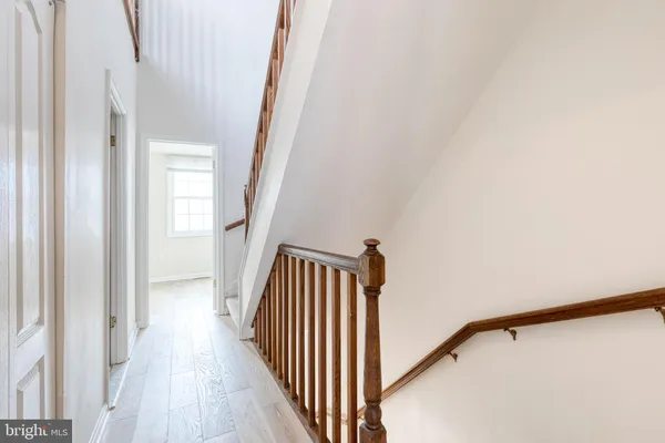 a view of a hallway with wooden floor and staircase