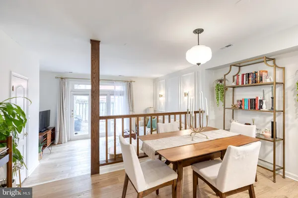 a view of a dining room with furniture wooden floor and a potted plant