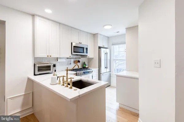 a kitchen with a sink a stove top oven and refrigerator