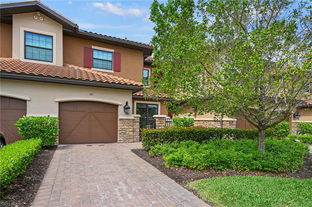 15245 Zeno Way, Unit 101 Naples, FL 34114 - Photo 1 of 46 a front view of a house with a yard and garage