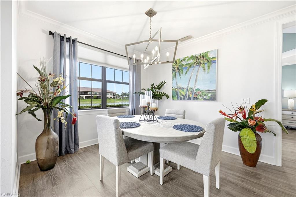 15245 Zeno Way, Unit 101 Naples, FL 34114 - Photo 13 of 46 a dining room with furniture potted plants and wooden floor