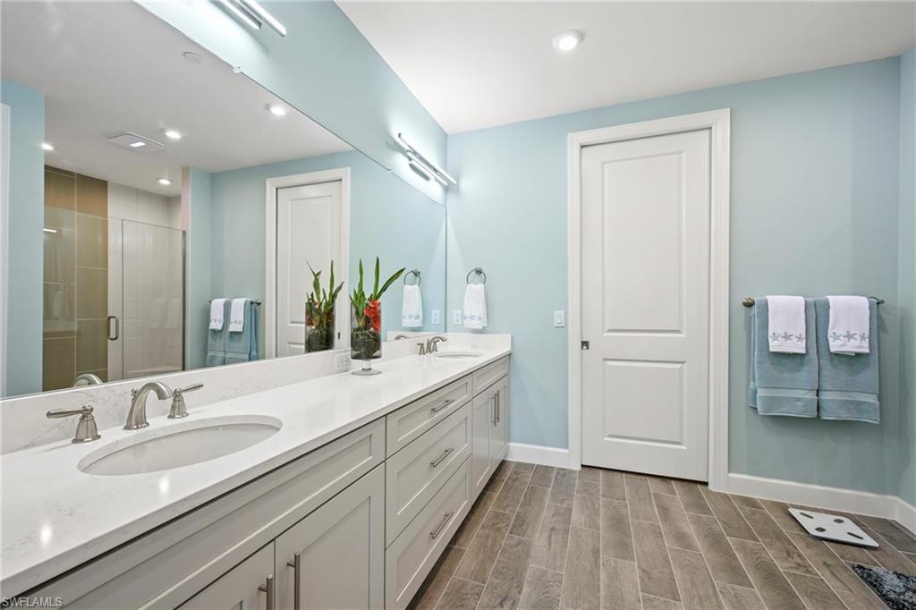 15245 Zeno Way, Unit 101 Naples, FL 34114 - Photo 18 of 46 a bathroom with a double vanity sink and a mirror