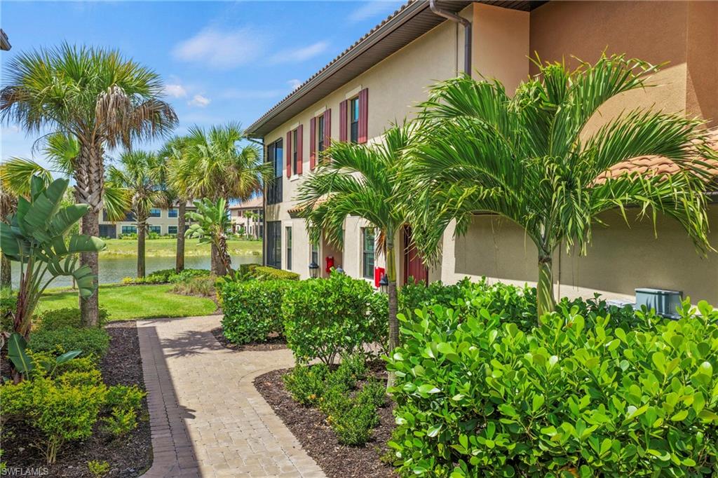 15245 Zeno Way, Unit 101 Naples, FL 34114 - Photo 2 of 46 a front view of house and yard with green space