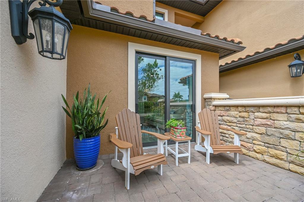 15245 Zeno Way, Unit 101 Naples, FL 34114 - Photo 22 of 46 a blue chair sitting in front of a house