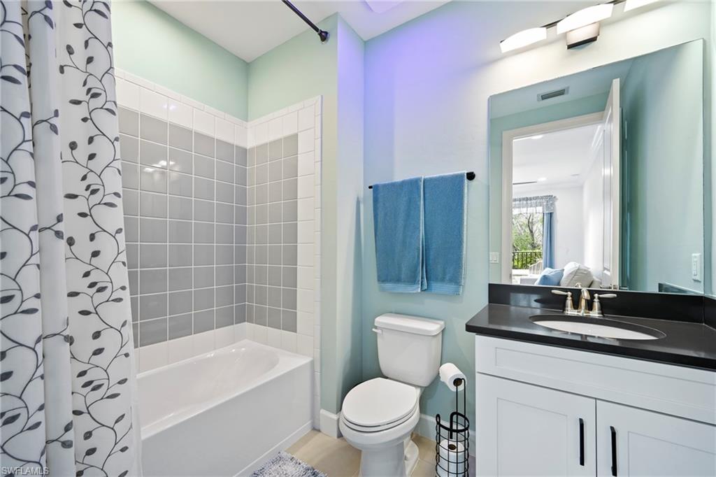 15245 Zeno Way, Unit 101 Naples, FL 34114 - Photo 24 of 46 a bathroom with a bathtub shower sink mirror vanity and toilet