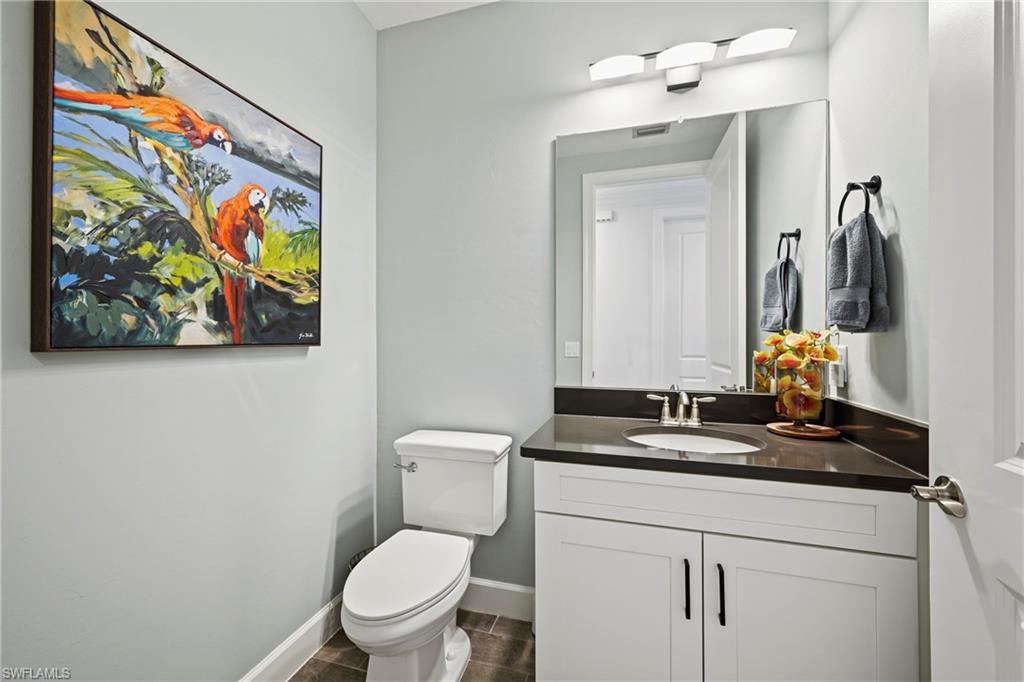 15245 Zeno Way, Unit 101 Naples, FL 34114 - Photo 27 of 46 a bathroom with a toilet a sink and a mirror