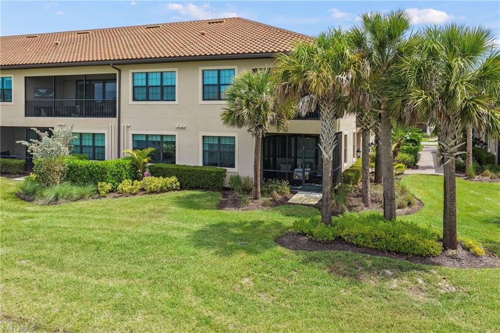 15245 Zeno Way, Unit 101 Naples, FL 34114 - Photo 31 of 46 a front view of a house with a yard and trees