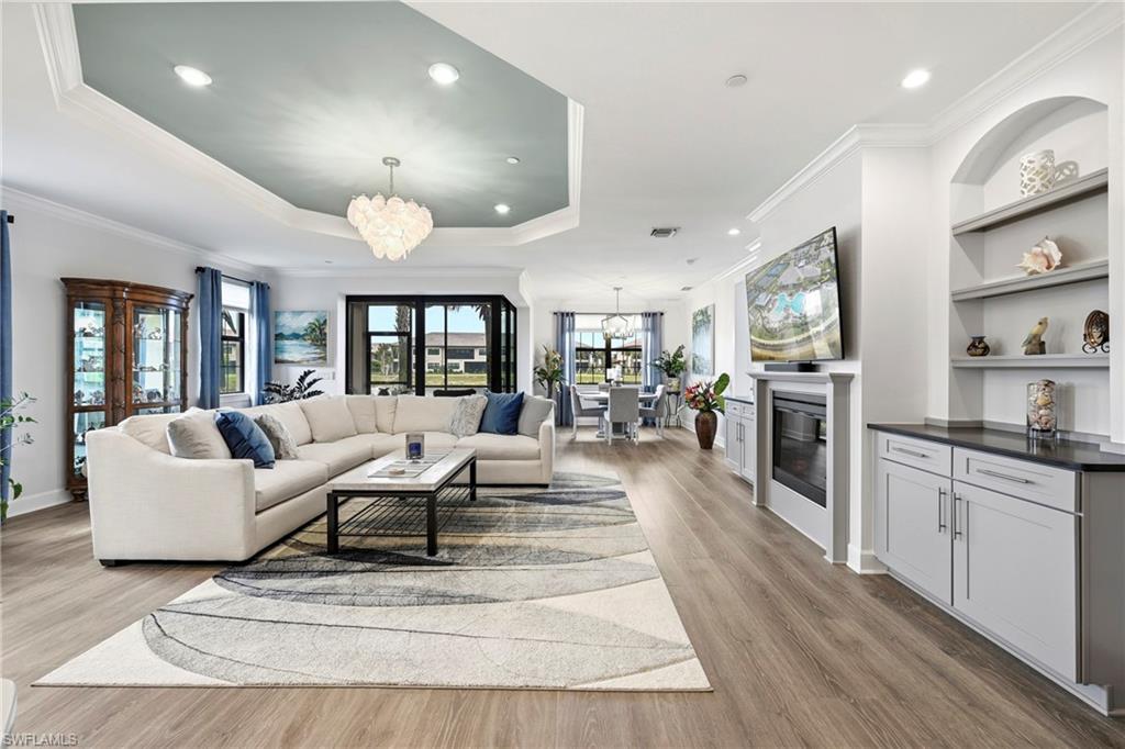 15245 Zeno Way, Unit 101 Naples, FL 34114 - Photo 4 of 46 a living room with fireplace furniture and a kitchen view