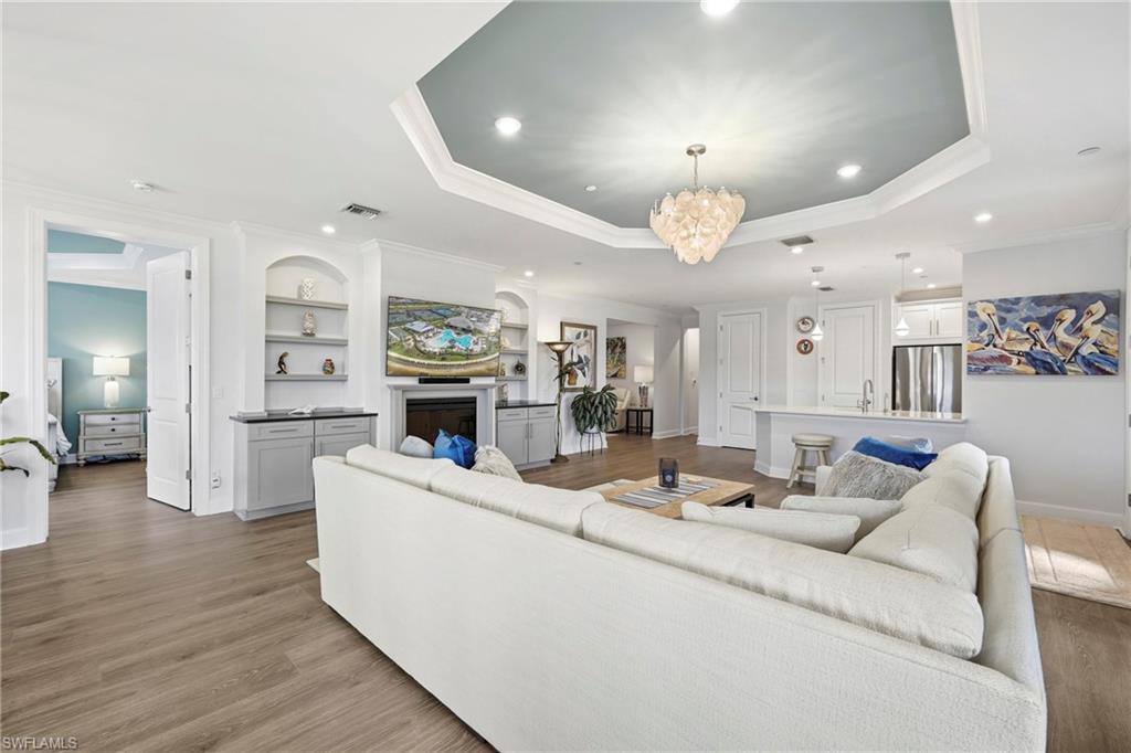 15245 Zeno Way, Unit 101 Naples, FL 34114 - Photo 6 of 46 a living room with furniture and a chandelier