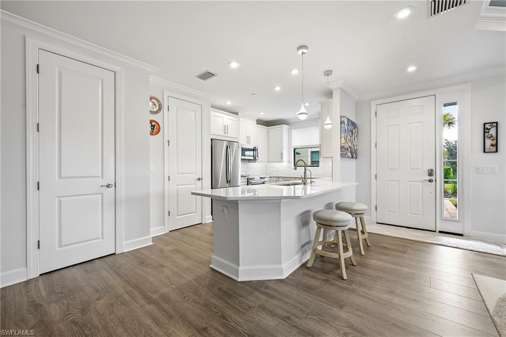 15245 Zeno Way, Unit 101 Naples, FL 34114 - Photo 7 of 46 a kitchen with a refrigerator and a sink