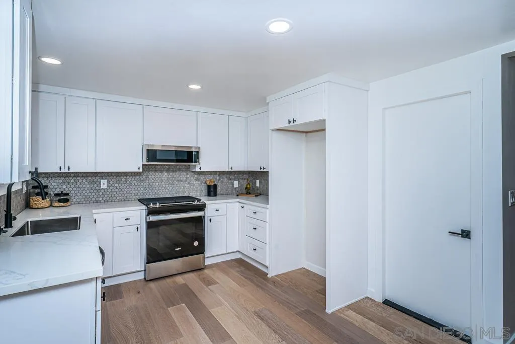 12710 McFeron Road Poway, CA 92064 - Photo 30 of 35 a kitchen with granite countertop white cabinets and white appliances