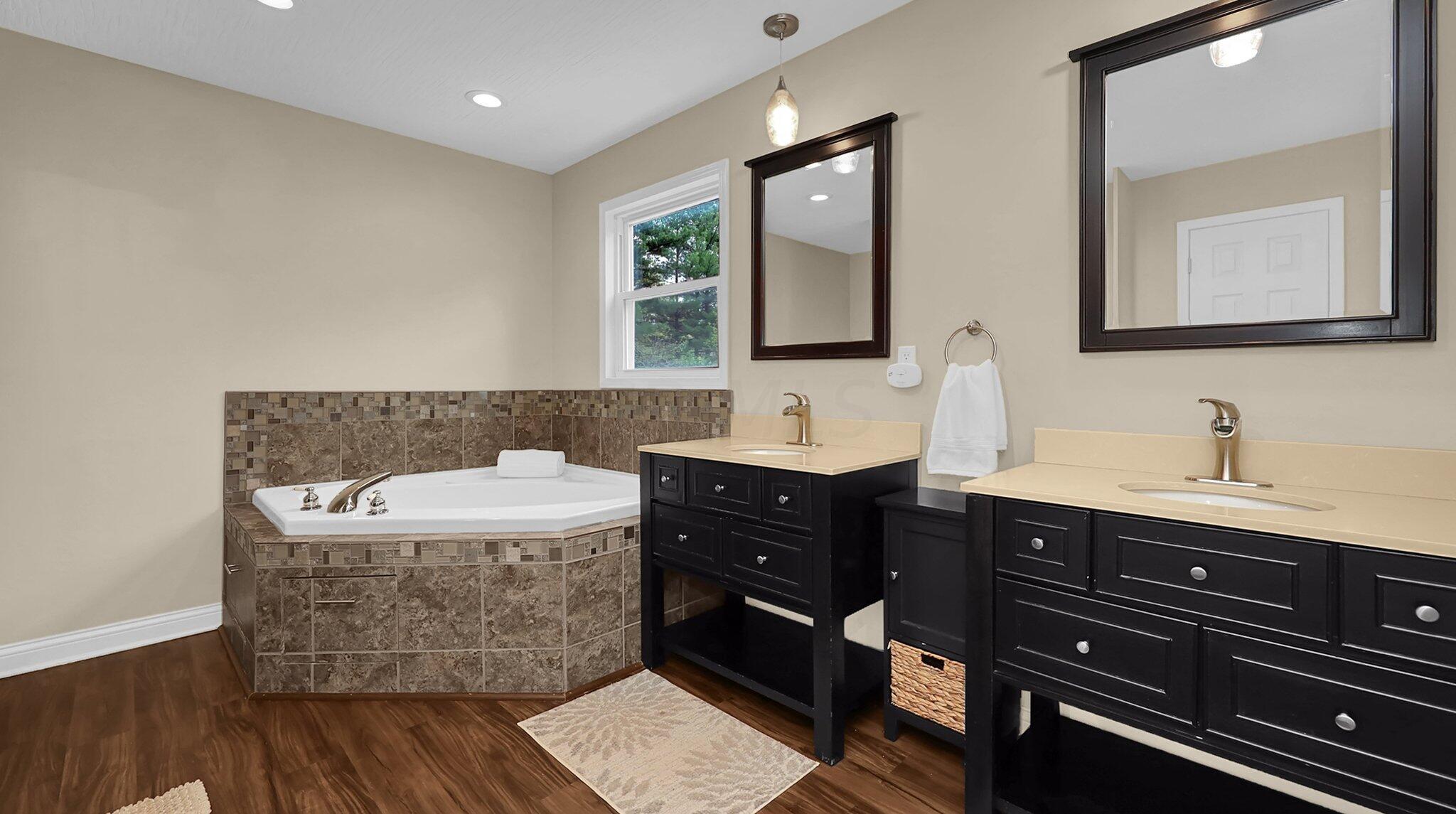 7790 Schott Road Westerville, OH 43081 - Photo 27 of 50 En-suite bathroom with dual vanities, updated lighting, tile surrounds, and lighting-ready for you to enjoy!