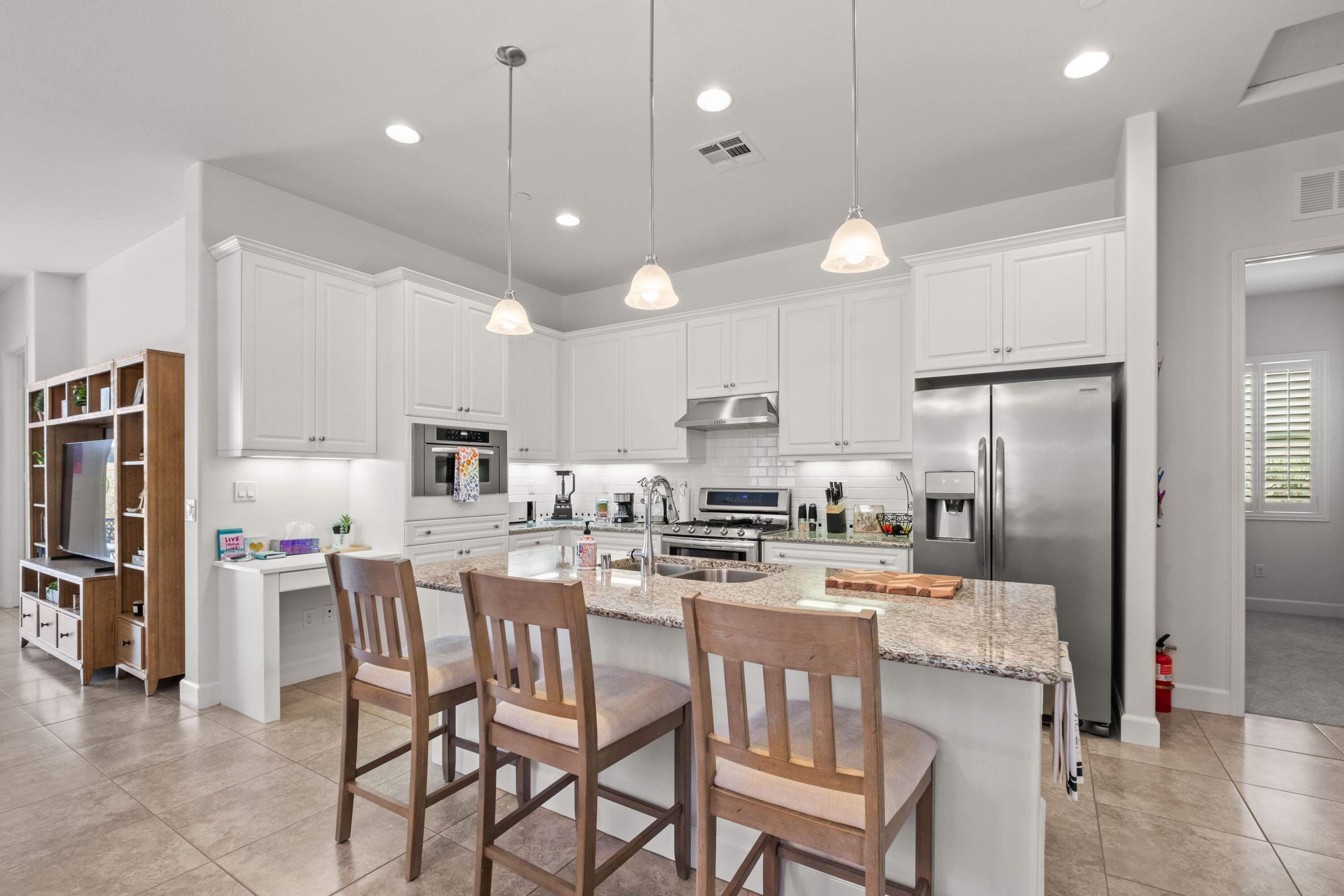 81360 Corte Compras Indio, CA 92203 - Photo 11 of 24 a kitchen with stainless steel appliances kitchen island granite countertop a dining table chairs refrigerator and microwave
