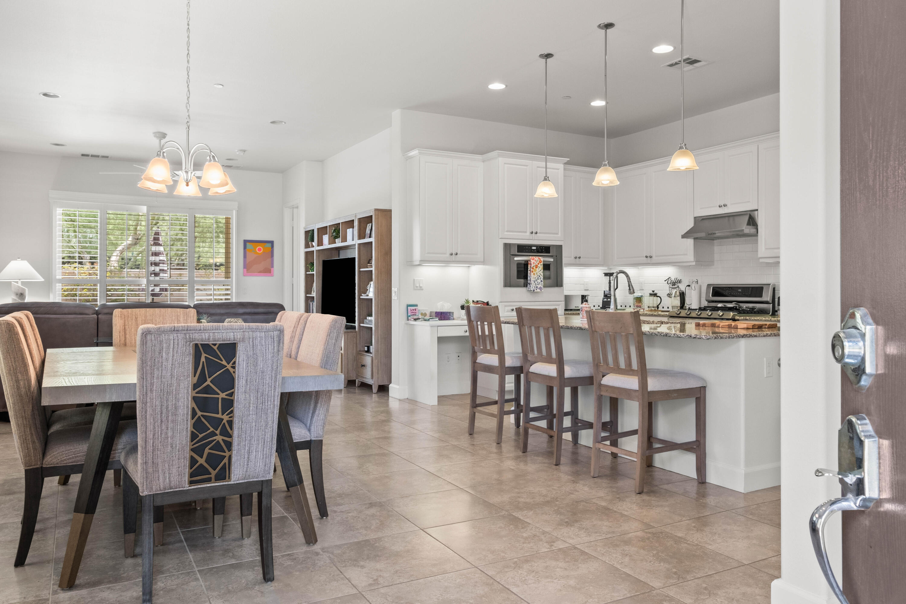 81360 Corte Compras Indio, CA 92203 - Photo 2 of 24 a dining room with stainless steel appliances kitchen island granite countertop a table chairs and a kitchen view