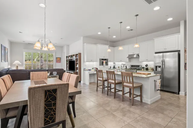 a large kitchen with kitchen island a dining table chairs and a oven