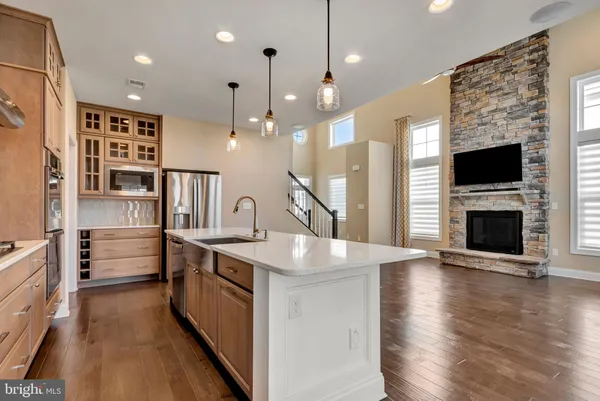 a kitchen with stainless steel appliances granite countertop a sink a stove and a wooden floors