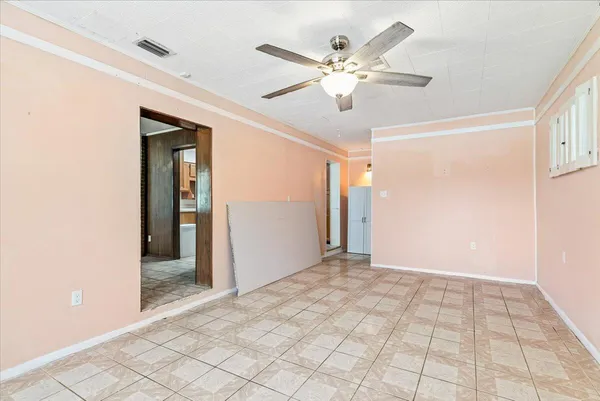 a view of a hallway with a chandelier fan and windows