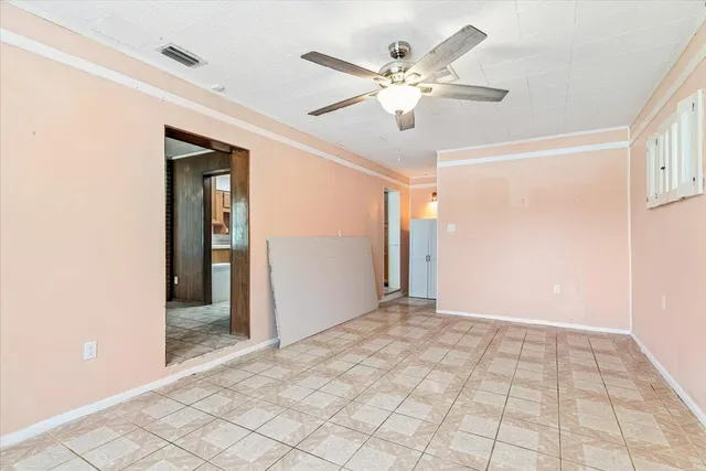 a view of a hallway with a chandelier fan and windows