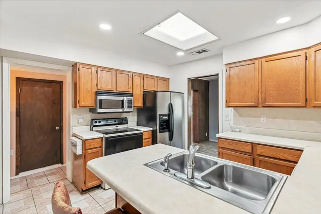 a kitchen that has a sink cabinets counter space and stainless steel appliances