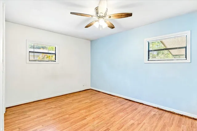 an empty room with a window and ceiling fan