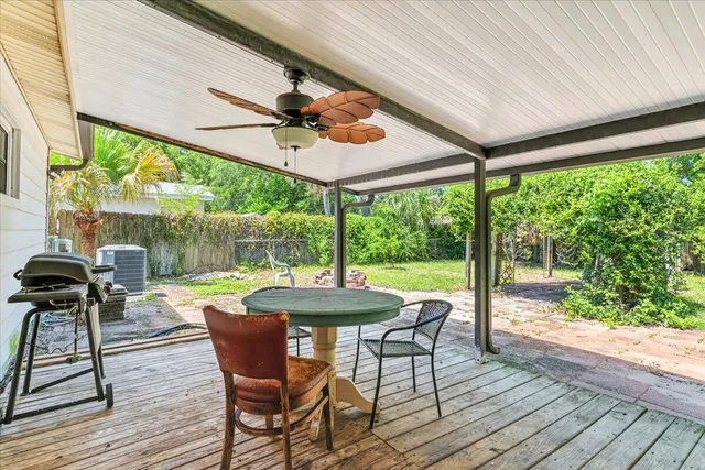 a patio with table and chairs and wooden floor