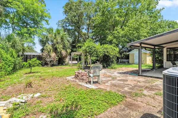 a view of a chair and table in backyard of the house